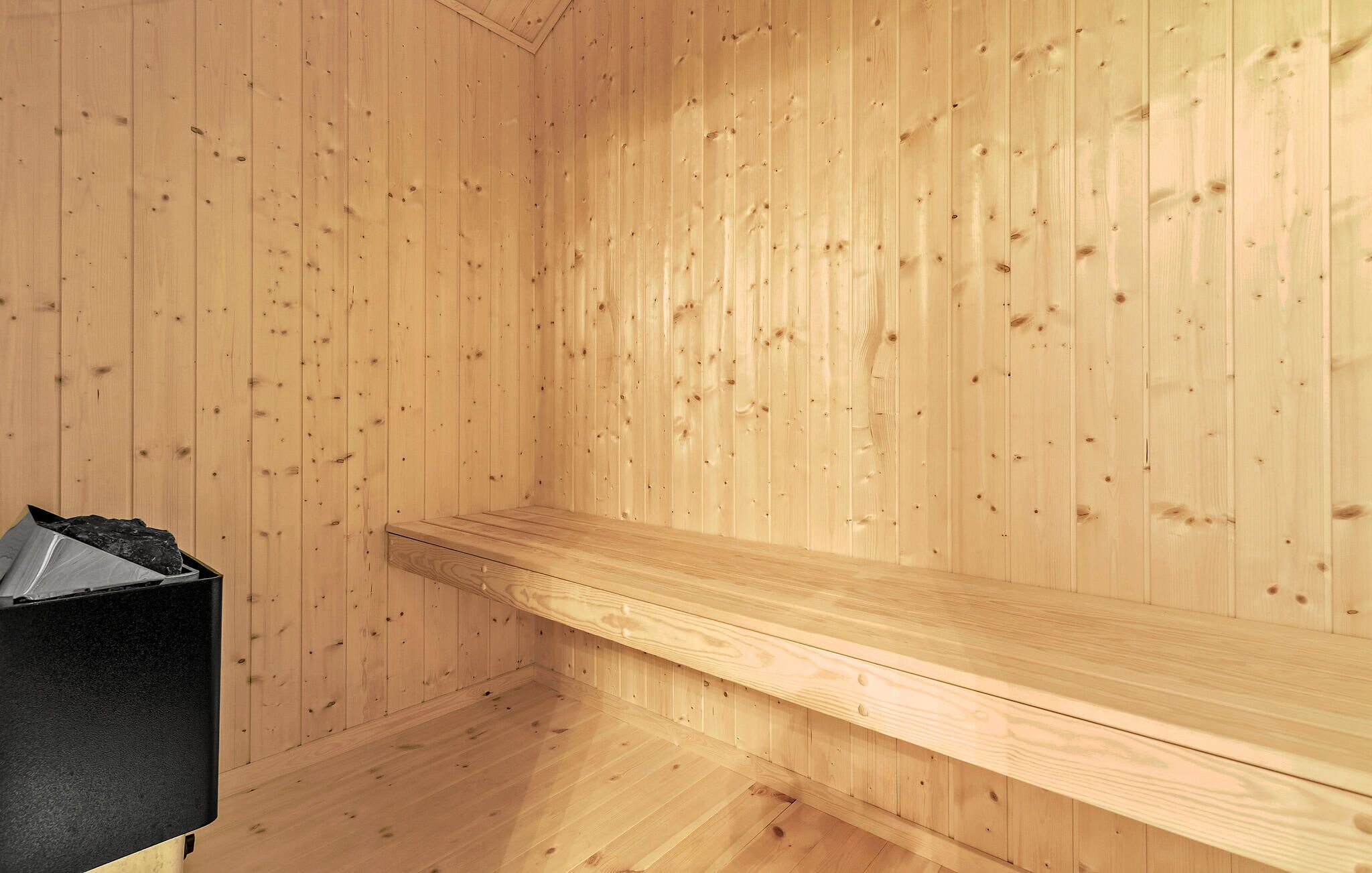 Sauna, jossa on puuseinät ja penkki.