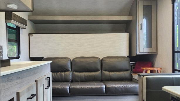 A compact kitchenette with a countertop, cabinets, and a microwave. - Cozy RV Vacation (Antioch)