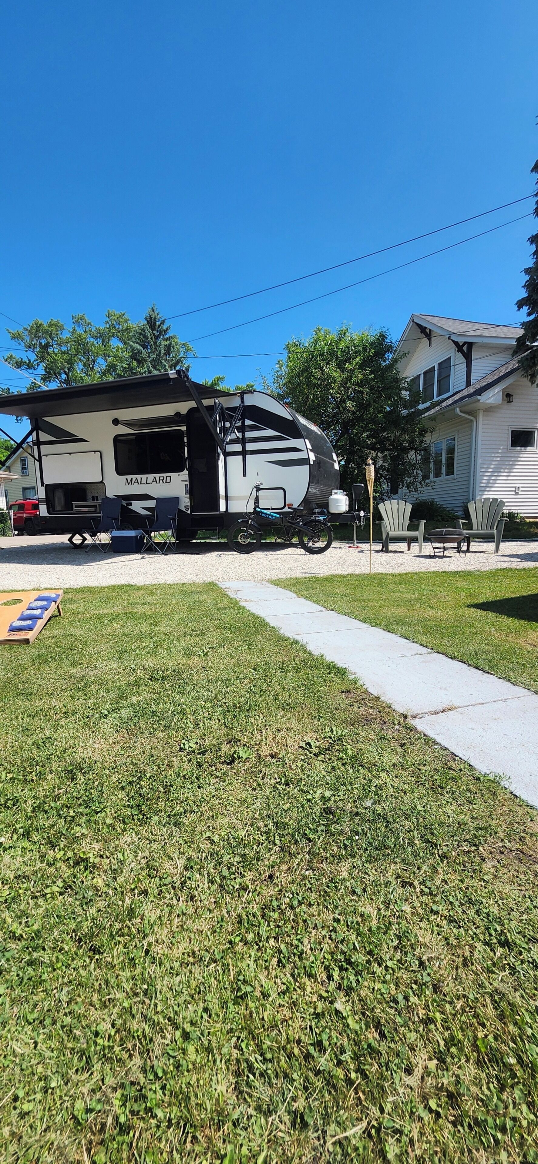 A recreational vehicle (RV) with a kitchen area, a dining table, and outdoor seating.