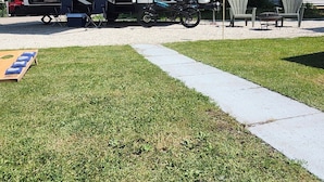 A recreational vehicle (RV) with a kitchen area, a dining table, and outdoor seating. - Cozy RV Vacation (Antioch)