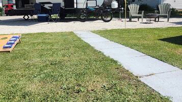 A recreational vehicle (RV) with a kitchen area, a dining table, and outdoor seating.