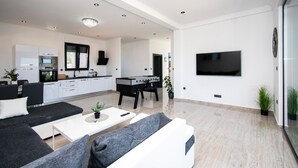 A modern living room with a sofa, coffee table, and a flat-screen TV mounted on the wall. - Awesome apartment in Brodarica with sauna (Brodarica)