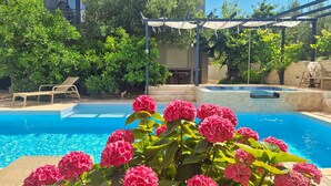 A swimming pool with a pergola, lounge chairs, and lush greenery. - Awesome apartment in Brodarica with sauna (Brodarica)