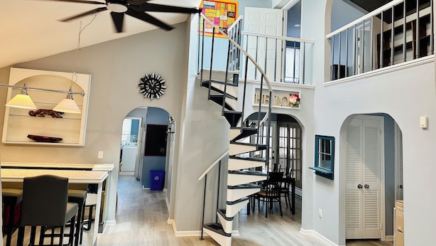 A spacious interior with a high ceiling, a central spiral staircase, and a dining area with chairs and a table. - Stylish Seaside Serenity with Pool Jersey Shore - Heart-Shaped Tub & Sunroom (Seaside Heights)