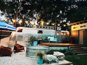 Een moderne RV-stijl woning met terras, buitenzitplaatsen en vuurkorf.