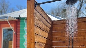 A wooden shower enclosure with a rain showerhead. - Silo house - 3 acres +pool +outdoor shower  “Opal” (Austin)