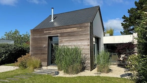Uma casa moderna de dois andares com telhado inclinado e chaminé.