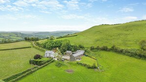 A rural house with a stone exterior, surrounded by lush green fields and a winding road. - 2 bedroom accommodation in Southgate, near Aberystwyth (Southgate, near Aberystwyth)