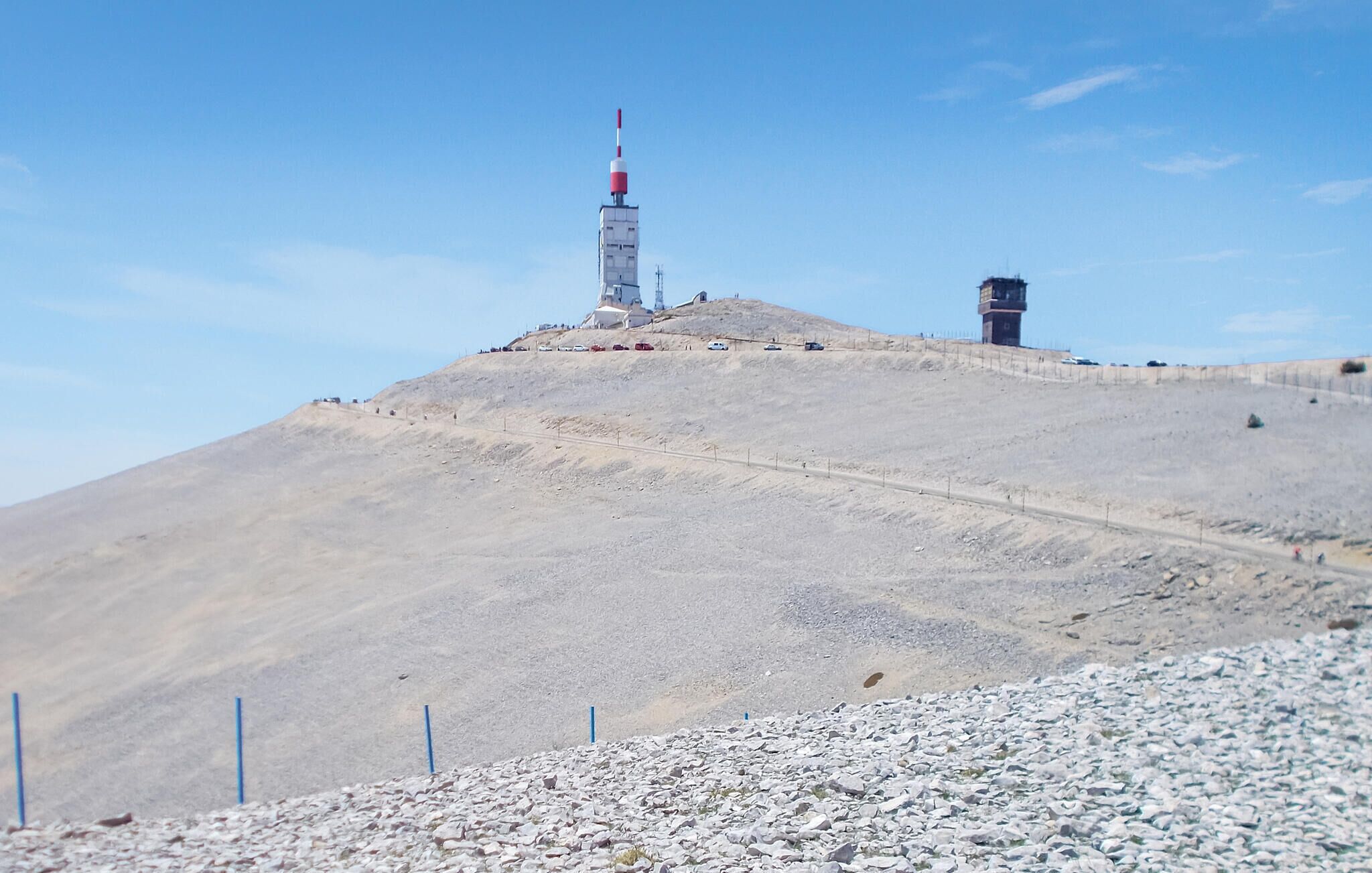 A barren hill with a tall tower and a smaller building on top.