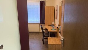 A hotel room with a wooden desk, a chair, a bed, and a wardrobe. - Hotel ISHI INN Wolfsburg (Wolfsburg)