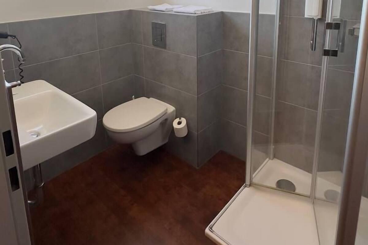 Un baño con ducha, inodoro y lavamanos.