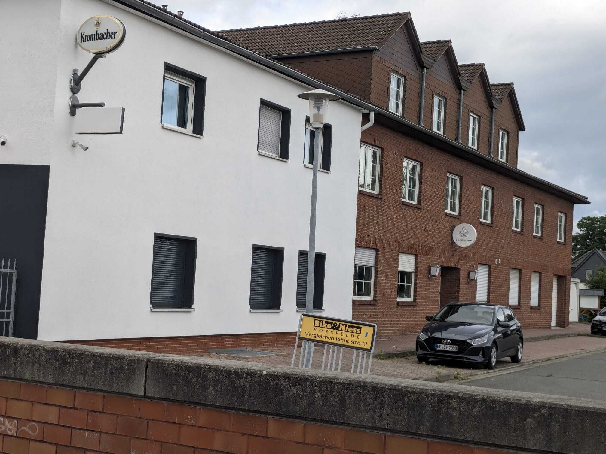 Un edificio con un cartel que dice 'Bike & Niess' y un cartel de 'Krombacher' en la fachada.