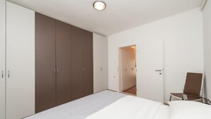 A bedroom with a bed, a wardrobe, and a chair.
