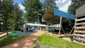 A playground with a slide and a covered seating area. - Log Cabin on Lake Alice & ATV/UTV Trails, Sister Bear 2-Bedroom (Tomahawk)