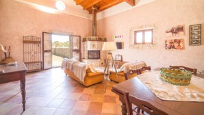 A cozy living room with a fireplace, a dining table, and a sofa. - Awesome home in Palazzo Adriano (Palazzo Adriano)