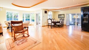 A spacious living area with a dining table, chairs, and a rocking chair.