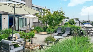 An outdoor patio area with seating, a table, and a large umbrella.