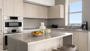 Una cocina moderna con electrodomésticos integrados, una isla grande y vistas al mar.