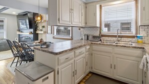 A modern kitchen with white cabinets, a granite countertop, and a built-in oven. - Spacious 3-BD Townhouse W/PKG 25M From Airport (Milwaukee)