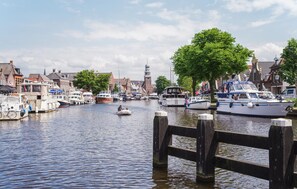 A canal with boats docked, a wooden pier, and buildings with traditional architecture. - 2 bedroom beautiful home in Lemmer (Lemmer)