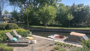 A riverside area with lounge chairs and a covered boat. - 2 bedroom beautiful home in Lemmer (Lemmer)