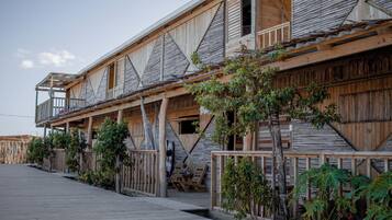 Um edifício de madeira com várias varandas e um deck de madeira.