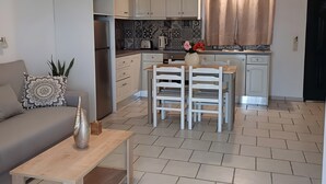 Un espacio habitable pequeño con kitchenette, comedor y sofá.
