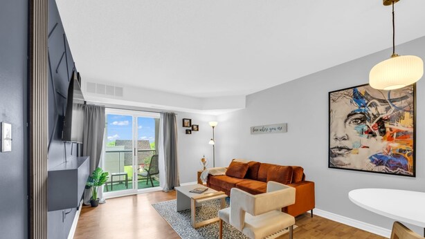 Un salon moderne comprenant un canapé, une table basse et un coin repas avec une table et des chaises.