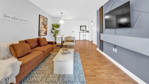 Un salon moderne avec un canapé, une table basse et un téléviseur fixé au mur.