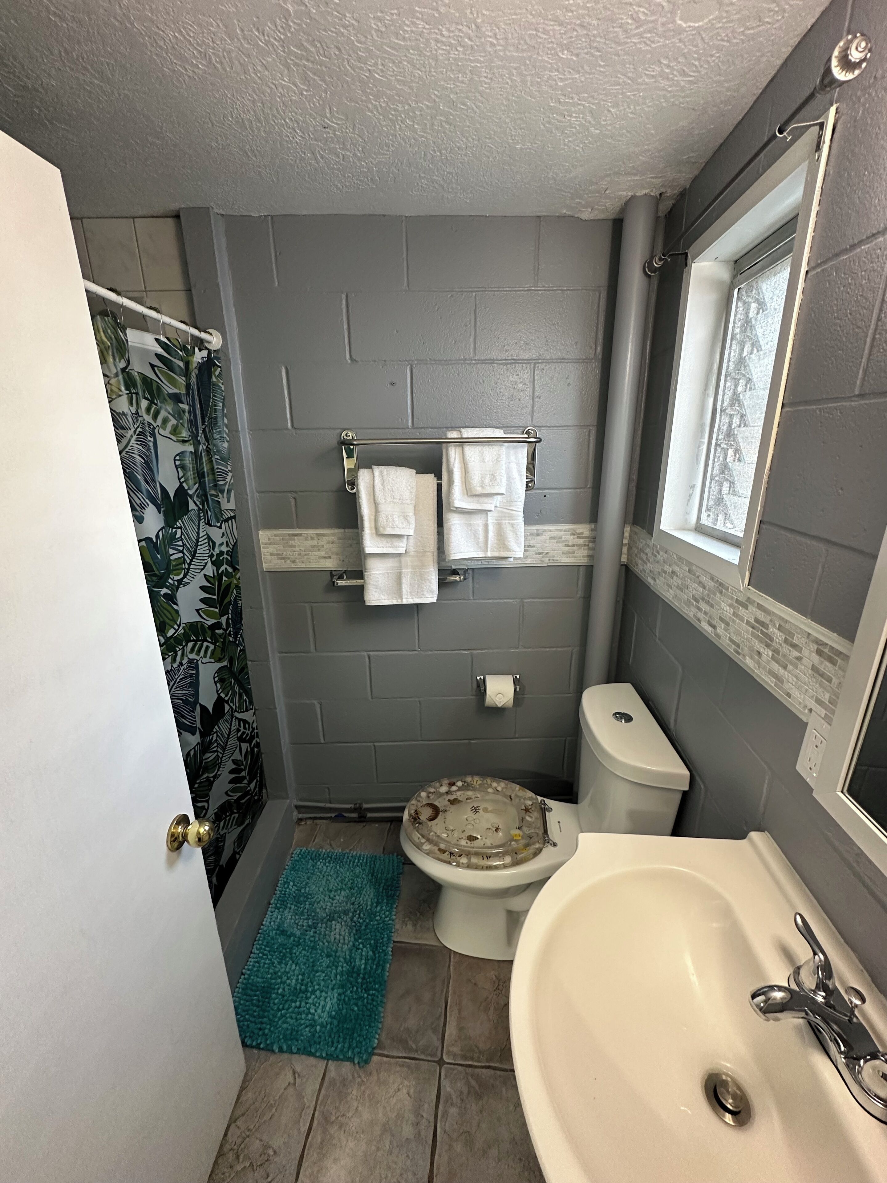 A bathroom with a toilet, sink, and towel rack.