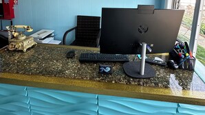 A reception desk with a computer, a telephone, and a framed certificate on the wall. - Old Orchard Beach Motel (Old Orchard Beach)
