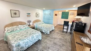 A bedroom with two beds, a desk, and a kitchenette. - Old Orchard Beach Motel (Old Orchard Beach)