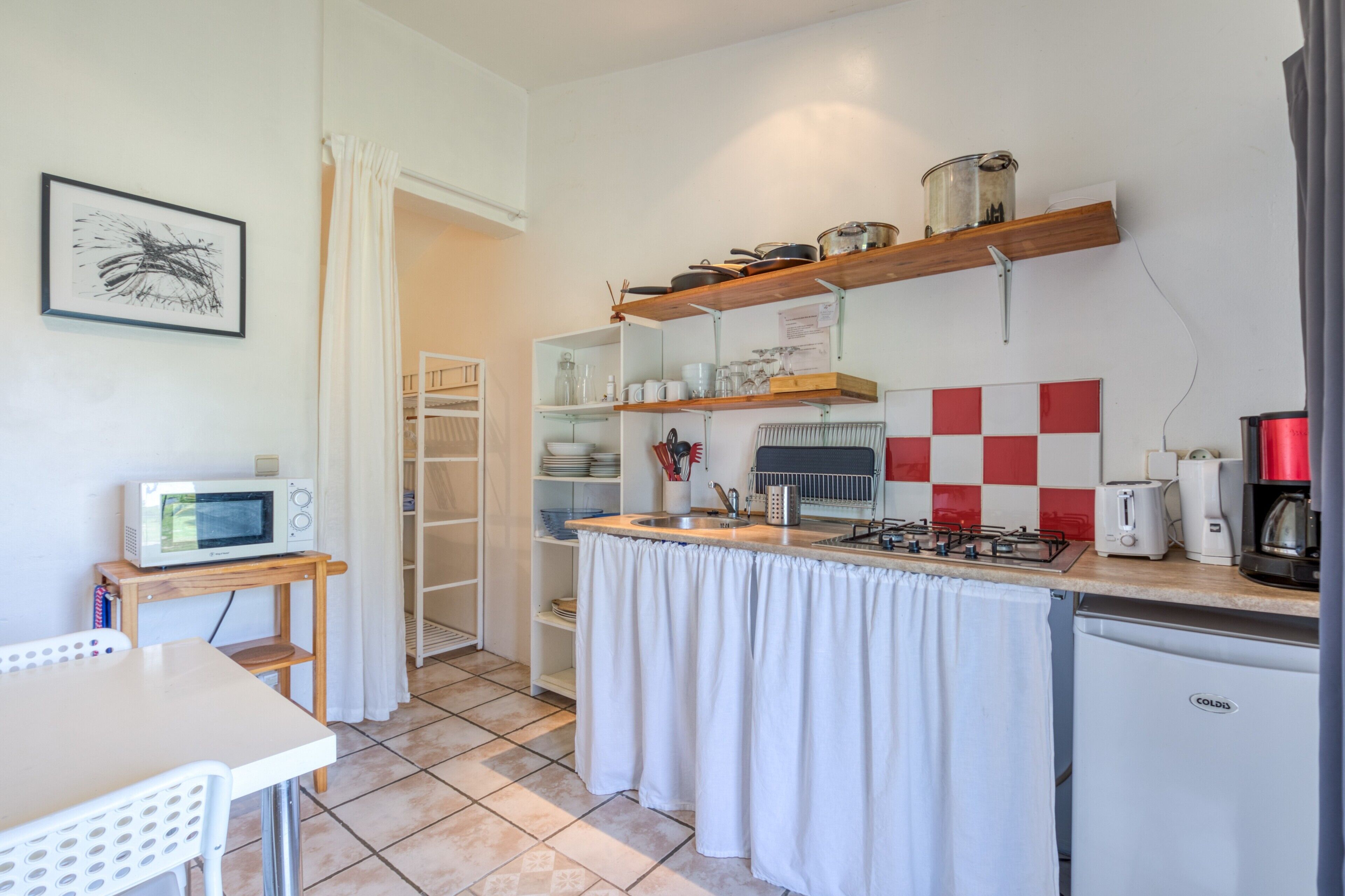 A compact kitchen with a microwave, stove, and refrigerator.