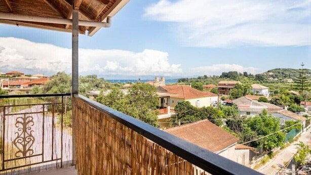 A balcony with a view of a town, wooden railing, and a metal gate. - Apartment 'Villa Dorita' with Sea View, Wi-Fi and Air Conditioning (Corfu)
