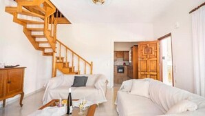 A living room with two white sofas, a wooden staircase, a wooden cabinet, and a glass coffee table. - Apartment 'Villa Dorita' with Sea View, Wi-Fi and Air Conditioning (Corfu)