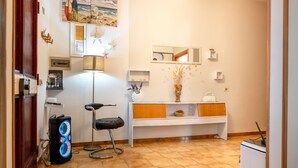 A room with a desk, chair, lamp, and a white cabinet with a mirror.