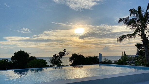 An infinity pool with a view of the ocean and sunset. - 1 Bedroom Apartment in Zanzibar (Zanzibar)