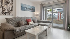 A modern living room with a sofa, a coffee table, and a painting on the wall. - Villa 'Adán' with Majestic Pool and Air Conditioning (Cádiz)