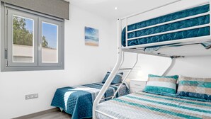 A bunk bed room with a window, a bedside table, and a wall-mounted painting. - Villa 'Adán' with Majestic Pool and Air Conditioning (Cádiz)