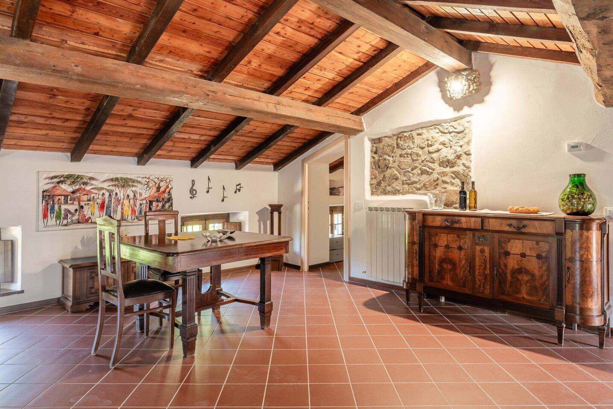 Un plafond en bois avec des poutres apparentes et un plancher gris.