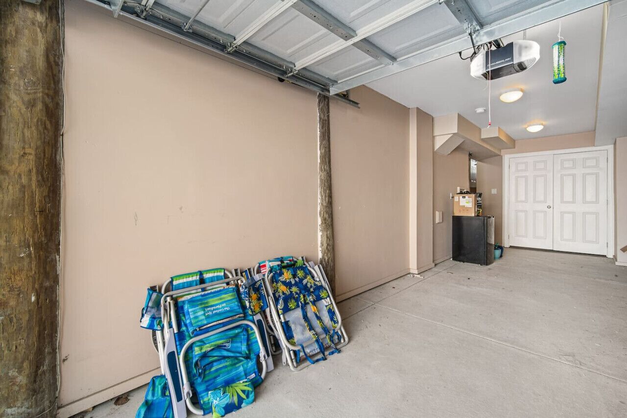 Un vaste espace intérieur avec un mur de couleur beige, un plafond avec des poutres apparentes et une porte visible au fond.