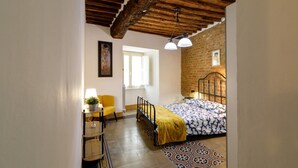 A bedroom with a bed, a chair, a desk, a lamp, and a window. - Castellare Degli Ugurgieri Central Apt in Siena (Siena)