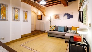 A cozy living room with a sofa, a lamp, and artwork on the walls. - Castellare Degli Ugurgieri Central Apt in Siena (Siena)