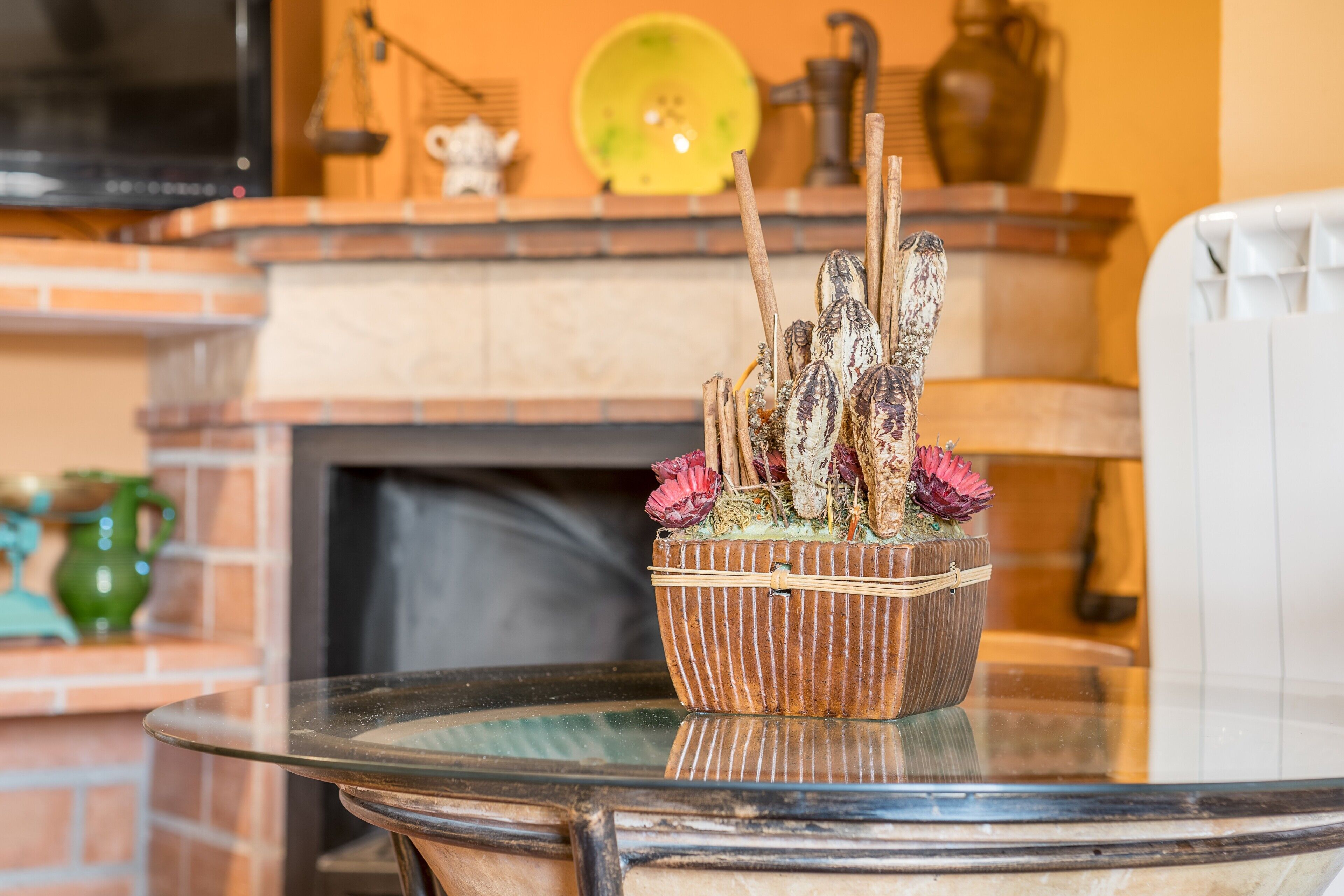 Une table en verre sur laquelle est posée une plante décorative dans un panier.