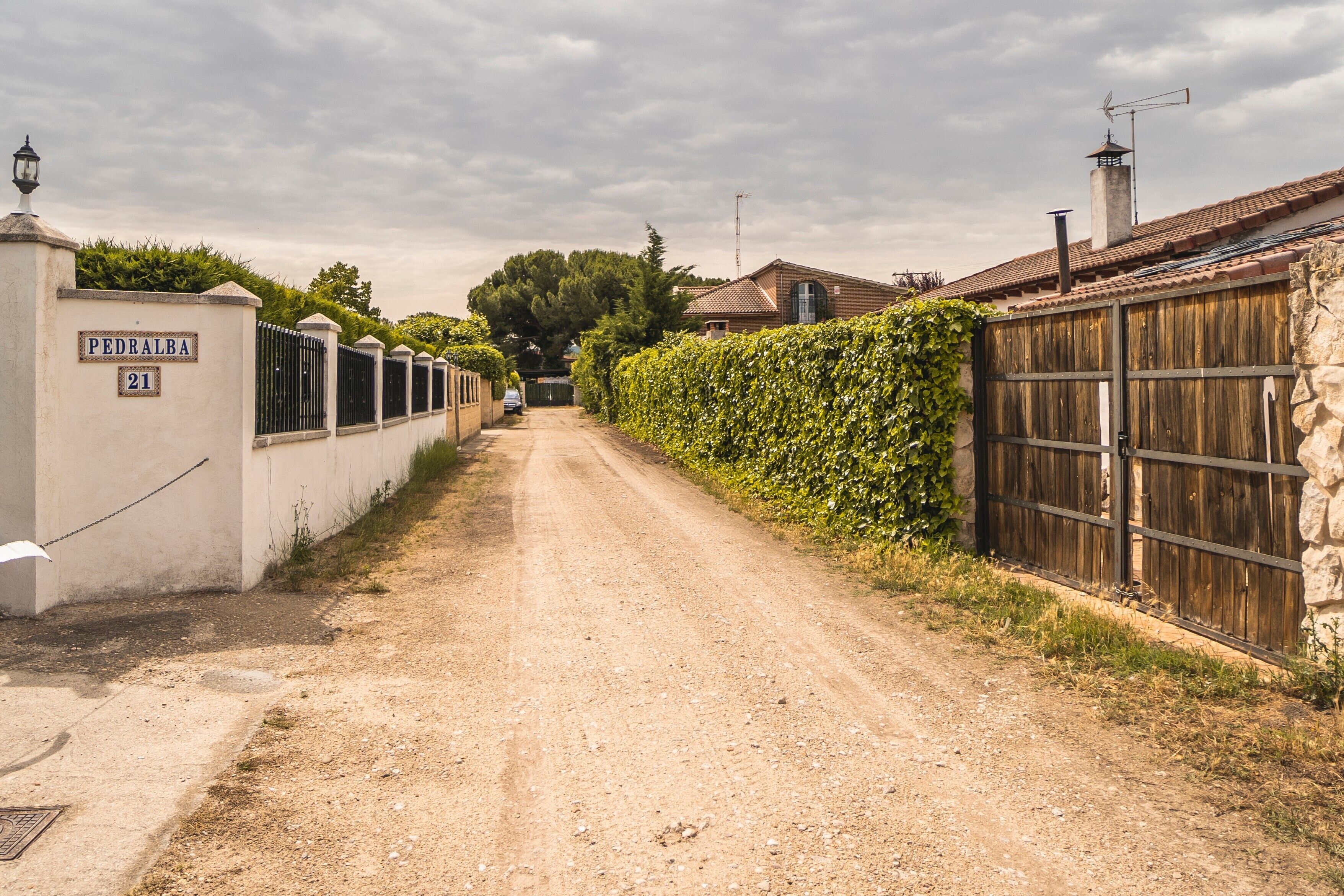 A rural road leading to a property with a sign reading 'PEDRALBA 21'.