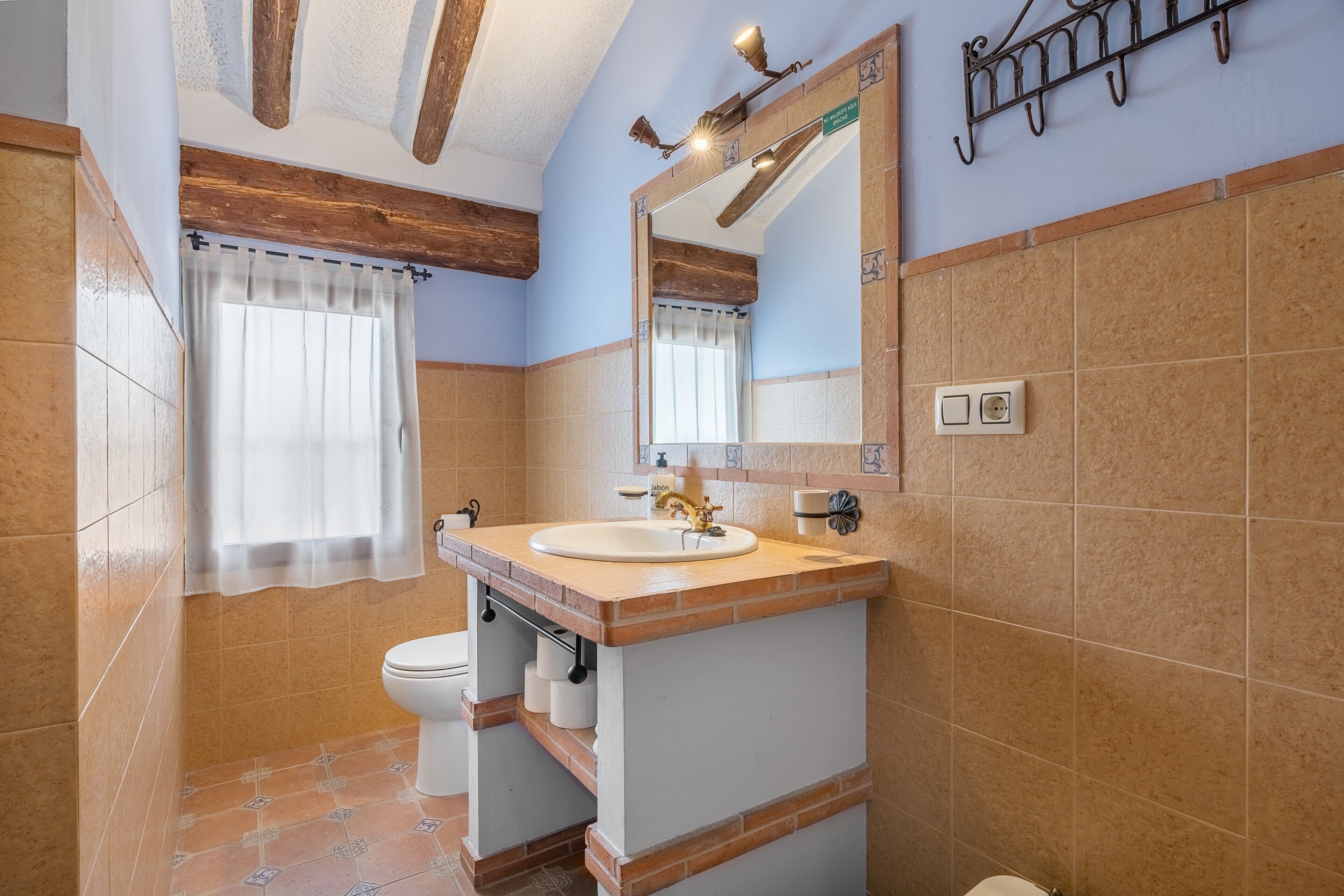 Un baño con lavabo, inodoro y espejo.