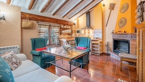 Ein gemütliches Wohnzimmer mit Kamin, Esstisch und zwei Stühlen.