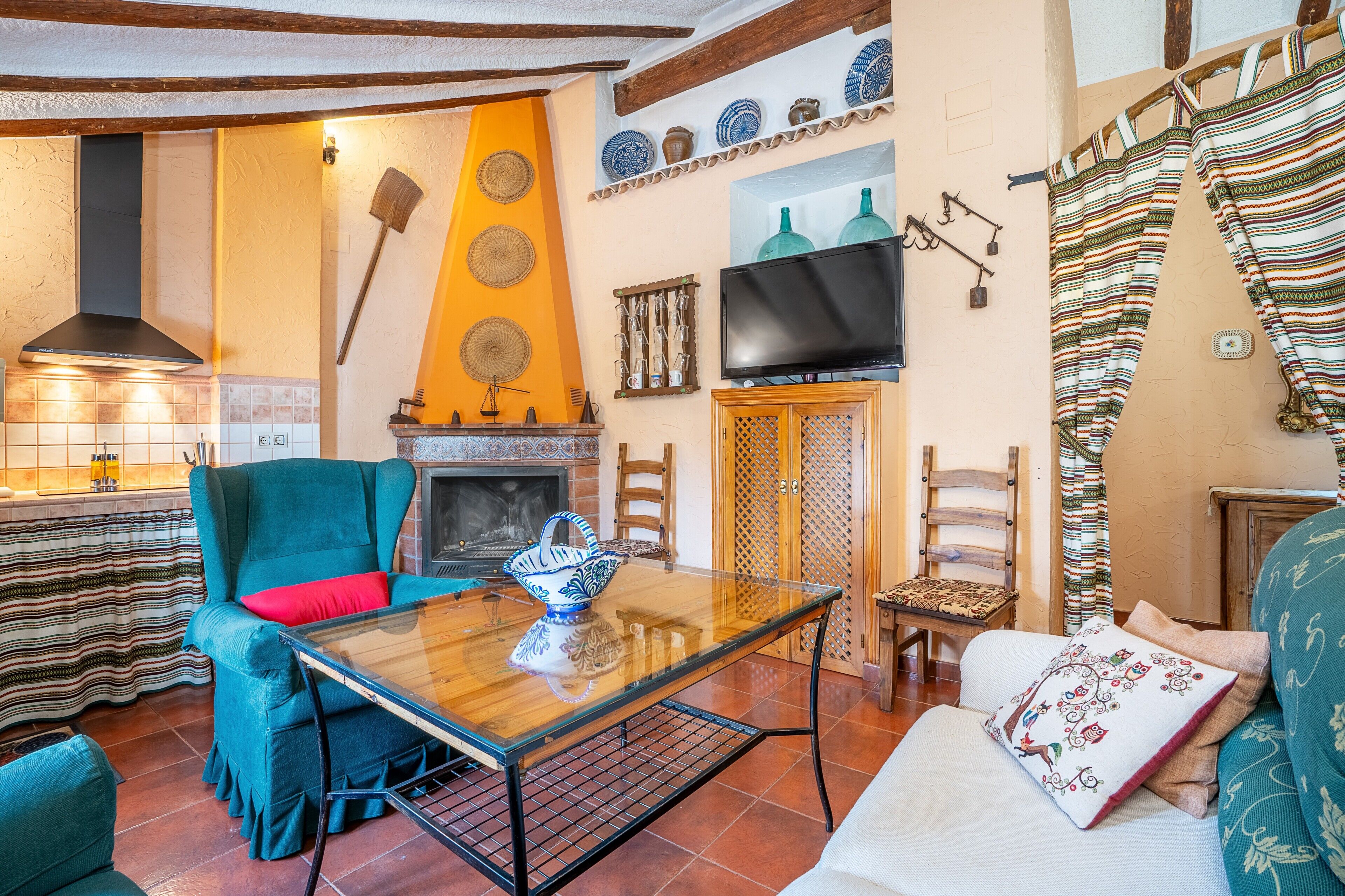 Ein Wohnzimmer mit Kamin, Fernseher und Essbereich mit Tisch und Stühlen.
