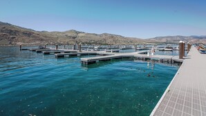 Een jachthaven met steigers die zich uitstrekken in kalm water, omringd door heuvels.