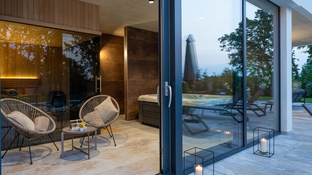 A modern interior with glass doors leading to a patio area.